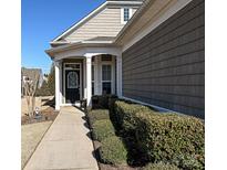 Charming home entrance featuring a decorative front door, well-manicured landscaping, and a welcoming covered porch at 8024 Carolina Lakes Way, Fort Mill, SC 29707
