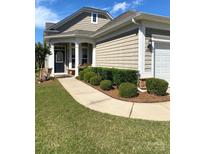 Charming home featuring a welcoming porch, manicured lawn, and tasteful landscaping with trimmed bushes along the walkway at 8024 Carolina Lakes Way, Fort Mill, SC 29707