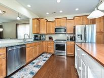 Well-lit kitchen features stainless steel appliances, granite countertops, and wood cabinets at 8024 Carolina Lakes Way, Fort Mill, SC 29707