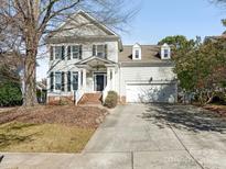 Two-story house with a brick walkway, attached two-car garage, and mature trees at 813 Garbow Ct, Charlotte, NC 28270