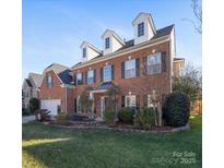 Brick home with dormer windows and landscaped lawn at 8440 Mossy Cup Trl, Harrisburg, NC 28075