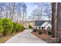 Charming home featuring a long driveway lined with trees and lush greenery at 926 Lone Oak Ln, Mooresville, NC 28115