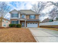 Two-story house with stone and siding, a large driveway and landscaped yard at 1120 Spicewood Pines Rd, Fort Mill, SC 29708