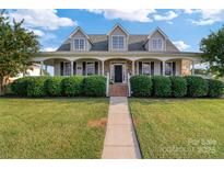 Two-story house with wrap-around porch, stone accents and manicured lawn at 1265 Maddy Ln, Rock Hill, SC 29732