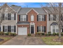 Charming brick townhome with attached garage, black shutters, and well-maintained landscaping at 153 Snead Rd # 72, Fort Mill, SC 29715