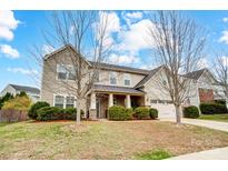 Charming two-story home featuring a welcoming front porch and well-maintained landscaping with mature trees at 2065 Taney Way, Fort Mill, SC 29707