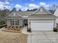 Charming single-story home with stone accents, well-maintained landscaping, and attached two-car garage at 23234 Kingfisher Dr, Indian Land, SC 29707