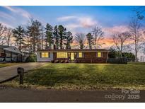 Charming single-story brick home boasting a spacious front yard and beautiful sunset skies at 2357 13Th Street Ne Dr, Hickory, NC 28601