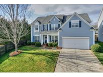 Charming two-story home featuring a well-manicured lawn, inviting entrance and an attached two-car garage at 265 Sutro Forest Nw Dr, Concord, NC 28027