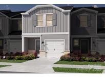 Two-story townhome with gray siding, white garage doors, and landscaping at 5046 Kellaher Pl, Charlotte, NC 28216