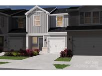 Two-story townhome with gray siding, white garage door, and landscaping at 5050 Kellaher Pl, Charlotte, NC 28216