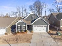 Gray two-story house with a two-car garage and landscaped yard at 5066 Summer Surprise Ln, Charlotte, NC 28215