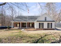 Charming ranch-style home featuring a covered front porch, black shutters, and a manicured lawn at 888 Brevard Place Rd, Iron Station, NC 28080