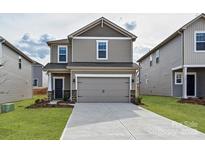 Two-story house with gray siding, two-car garage, and landscaping at 909 Smithcliffs Trl, York, SC 29745