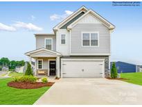 Charming two-story home featuring a covered porch, two-car garage, and beautifully landscaped front yard at 11027 Daisy Ct, Charlotte, NC 28262