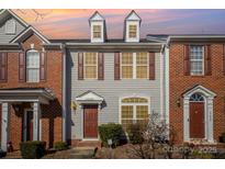 Brick front exterior of townhome with gray siding and brown door at 17629 Delmas Dr, Cornelius, NC 28031