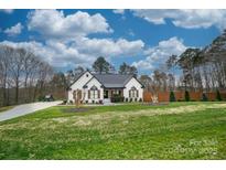 Ranch style home with white brick exterior, landscaping, and long driveway at 31934 Ameron Cir, Albemarle, NC 28001