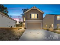 Two-story house with beige siding, a garage, and a well-maintained front yard at 3220 Capitol Dr, Charlotte, NC 28208