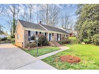 Charming brick home featuring manicured lawn and walkway to the front entrance at 3828 Chandworth Rd, Charlotte, NC 28210