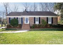 Charming brick home with manicured lawn, black shutters and inviting front porch at 3828 Chandworth Rd, Charlotte, NC 28210