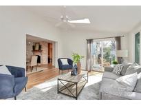 Bright living room with a ceiling fan, modern furniture, and sliding glass doors at 3828 Chandworth Rd, Charlotte, NC 28210