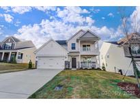 Two-story house with white siding, stone accents, and a two-car garage at 5036 Heathland Dr # 71, Charlotte, NC 28215