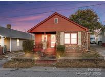 Charming brick home featuring a cozy front porch and well-maintained landscaping at 630 N Moran St, Gastonia, NC 28052