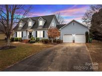 Two-story house with gray siding, two-car garage, and landscaping at 841 Deerfield Dr, Mount Holly, NC 28120