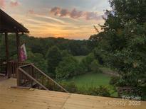 Peaceful sunset view from deck, overlooking expansive backyard and trees at 1262 Ring Tail Rd, Claremont, NC 28610