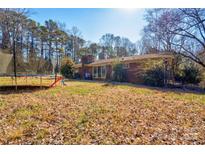 Expansive backyard with a trampoline, mature trees, and plenty of space for outdoor activities at 1900 E Dixon Blvd, Shelby, NC 28152