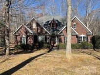 Charming brick home with a manicured lawn and mature trees offering curb appeal at 2113 Sweet Clover Way, Denver, NC 28037