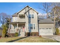 Two-story craftsman style home with red door, attached garage, and manicured lawn at 2408 Rozzelles Ferry Rd, Charlotte, NC 28208