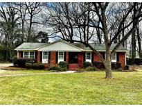 Brick ranch house with a well-maintained lawn and mature trees at 3019 Parkstone Dr, Charlotte, NC 28210