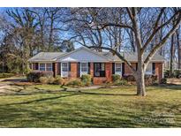 Brick ranch home with landscaped lawn and mature trees at 3019 Parkstone Dr, Charlotte, NC 28210