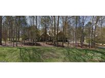 Brick house with large windows and mature trees on a spacious lot at 4025 Weddington Manor Ct, Matthews, NC 28104