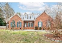 Brick house with teal shutters, a landscaped yard, and a charming front porch at 4025 Weddington Manor Ct, Matthews, NC 28104