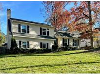 Two-story house with a white brick facade, black shutters, and a well-manicured lawn at 6737 Lancer Dr, Charlotte, NC 28226