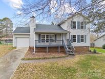 Two-story house with gray deck, attached garage, and landscaped lawn at 212 King George Ln, Gastonia, NC 28056