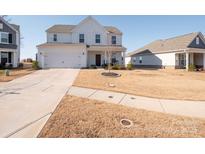 Two-story home with white siding, a two-car garage, and a well-maintained lawn at 450 Caleb St, Monroe, NC 28110