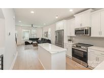 Bright, open-concept kitchen with stainless steel appliances and a center island with a marble countertop at 5048 York Park Ln, Charlotte, NC 28217