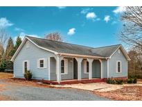 Ranch style home with light blue siding, covered porch, and a landscaped yard at 5704 Bentgrass Ct, Monroe, NC 28110