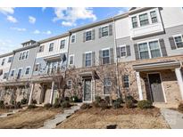 Modern townhouses with gray siding, stone accents, and landscaping at 7840 Denmark Rd, Charlotte, NC 28273