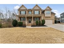 Charming two-story brick home with a welcoming front porch and well-manicured lawn at 829 Palmetto Bay Dr, Fort Mill, SC 29715