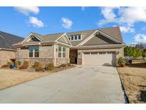Charming single-Gathering home features a well-manicured lawn and attached two car garage with a spacious driveway at 9428 Liberty Hill Dr, Mint Hill, NC 28227