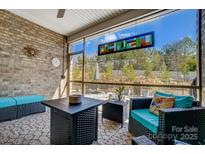 Cozy screened-in back porch with outdoor furniture and decor offering great backyard views at 9428 Liberty Hill Dr, Mint Hill, NC 28227