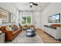 Bright living room with leather sofa and large windows at 3116 Beacon Heights Rd, Indian Land, SC 29707