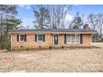 Charming brick ranch-style home featuring well-maintained landscaping and a classic facade with black shutters at 445 Providence Rd, Lancaster, SC 29720