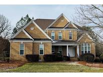 Charming two-story brick home featuring white trim, well-manicured lawn, and mature landscaping at 561 Keystone Nw Ct, Concord, NC 28027