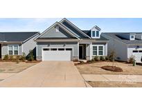 Charming single Gathering home features a two-car garage, stone accents, and manicured landscaping at 8016 Brookbank Dr, Charlotte, NC 28269