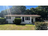 Charming white brick home with a well-maintained lawn and covered carport, perfect for outdoor living at 2334 Woodleaf Dr, Gastonia, NC 28052
